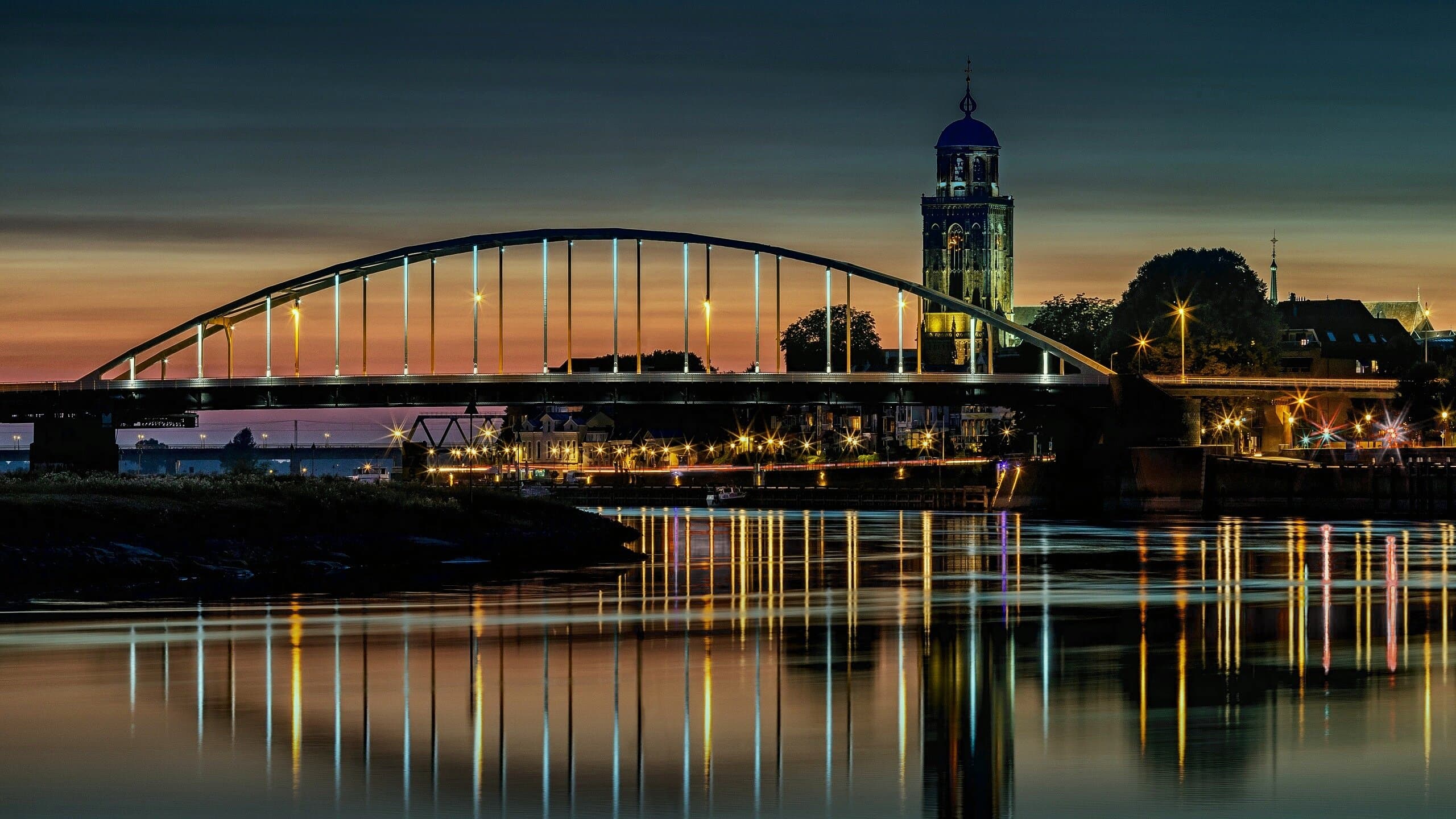 De Wilhelminabrug over de IJssel met de Lebuinustoren in Deventer bij avond